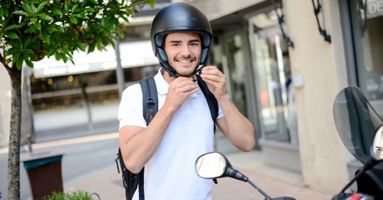 Man putting on helmet for motorcycle