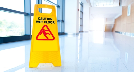 Wet floor sign in office hallway